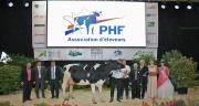 Twin Uzelli, appartenant au Gaec Leclerc et à Bruno Toussaint, a remporté le titre de grande championne du concours national prim'holstein 2014. Elle pose sous le tout nouveau logo de Prim'Holstein France, dévoilé quelques minutes avant sa désignation. Photo: JLC